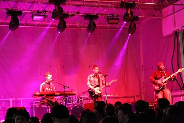 Funkharp on stage in pink light, seen from the crowd.